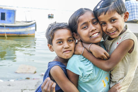 VARANASI, INDIA - DEC 11:  children pose for fotografers on December 11, 2011 in India, Varanasi. Some hope to get a gift and sometimes ask for money.のeditorial素材