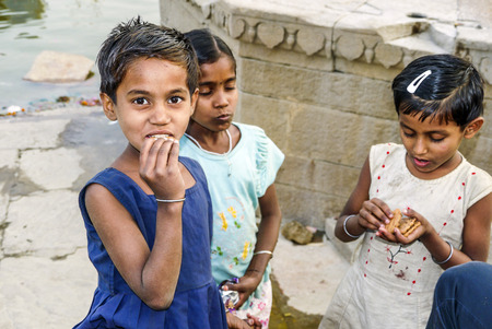 VARANASI, INDIA - DEC 11:  children pose for fotografers on December 11, 2011 in India, Varanasi. Some hope to get a gift and sometimes ask for money.のeditorial素材
