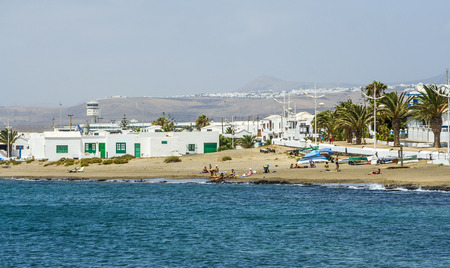 ARRECIFE, SPAIN - AUG 9: people relax at the beach on Aug 9, 2007 in Arrecife, Spain. The beach lies beside the airport and planes cross the beach by landing.のeditorial素材