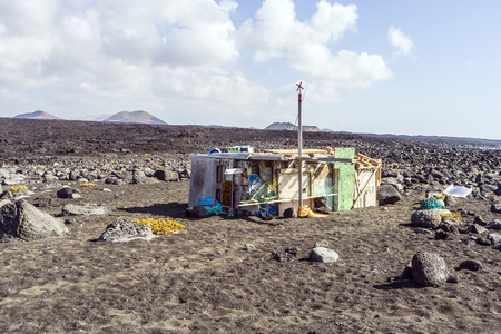 TIMANFAYA, SPAIN - AUG 12: fishermans hut in Timanfaya volcanic park on August 12, 2007 in Timanfaya, Spain, This beach is only acessible by the ocean and forbidden to enter without permission.のeditorial素材