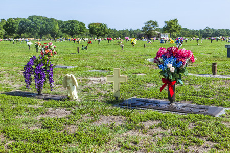 SVANSBORO, USA - JULY 20: american cemetery with flowers at the graves at July 20, 2010 near Svansboro, USA. In US there are more than 300000 cemeteries without private ones.のeditorial素材