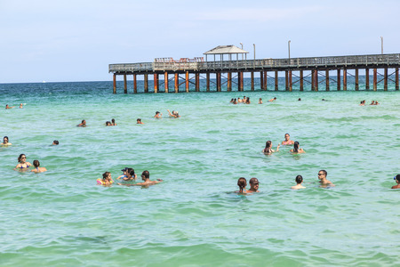 SUNNY ISLES BEACH, USA - JULY 31: people enjoy swimming near the pier on July 31, 2010 in Sunny Isles Beach, USA. In 1936, Milwaukee malt magnate Kurtis built the Sunny Isles pier.のeditorial素材