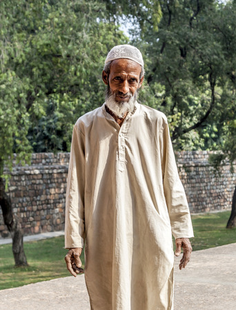 DELHI, INDIA - NOVEMBER 11, 2011: A muslim tribal man wearing traditional taqiyah (muslim cap) and galabia poses in the garden of Hayumans tomb in Delhi, India.のeditorial素材