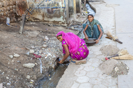 BIKANER, INDIA - OCT 24, 2012: woman tries to find gold dust in the canalisation of the gold smith area in Bikaner, India.のeditorial素材
