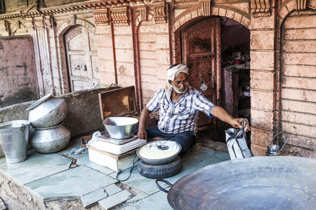 BIKANER, INDIA - OCT 24, 2012: man sells delicious curd in the streets of Bikaner, India. Curds are a dairy product obtained by curdling milk with rennet or any edible acidic substanc.のeditorial素材