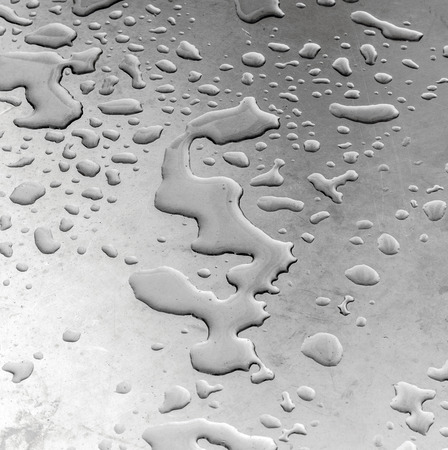 water on silver metal table in harmonic formの写真素材