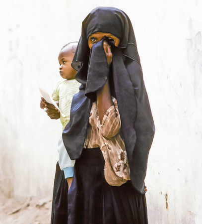 HADHRAMAUT, YEMEN - MAY, 15: arabic unknown mother carries her baby in a  wraparound garment on May 15, 1993 in Hadhramaut, Yemen. in 2008 still 62 percent of women in rural areas are  illiteracy.のeditorial素材