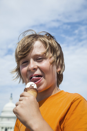 young boy eating a tasty ice cream  with the capitolの写真素材