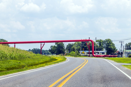 red pipeline crosses the street in Americaの写真素材