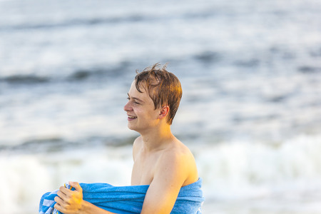 portrait of handsome teenager at the beach in sunsetの写真素材