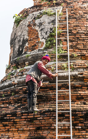 AYUTTHAYA, THAILAND - DEC 24, 2009: worker at temple area in Ayutthaya, Thailand. The Ayutthaya historical park covers the ruins of the old city of Ayutthaya, Thailand.のeditorial素材