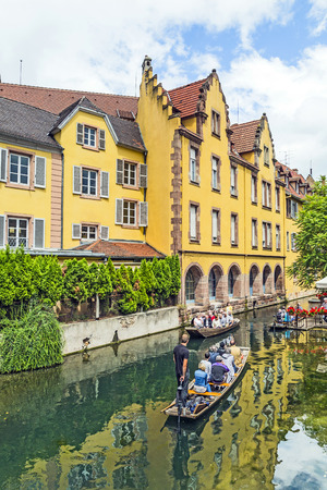 COLMAR, FRANCE - JULY 3, 2014: People enjoy a boat trip near traditional half-timbered houses in Colmar, France. Colmar is also called Little Venice because of many ancient canals in town.のeditorial素材