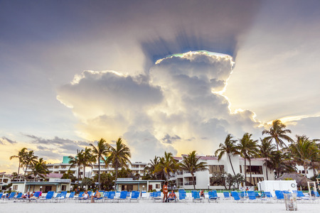 MIAMI, USA - JULY 30, 2010: people enjoy playing Volleyball im Miami, USA. Dark clouds with spectacular light refractions in rainbow colors illuminate the scene.のeditorial素材