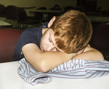 young boy sleeps with head on the table