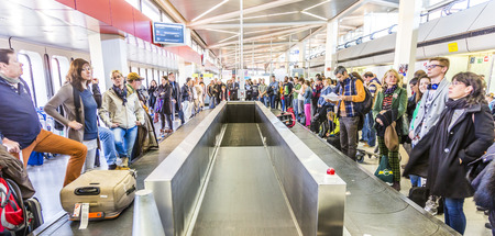BERLIN, GERMANY - OCT 27, 2014: people wait at baggage belt  in  Tegel airport, Berlin, Germany.  It is the fourth busiest airport in Germany with . over 19.59 million passengers in 2013.のeditorial素材