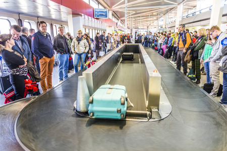 BERLIN, GERMANY - OCT 27, 2014: people wait at baggage belt  in  Tegel airport, Berlin, Germany.  It is the fourth busiest airport in Germany with . over 19.59 million passengers in 2013.のeditorial素材