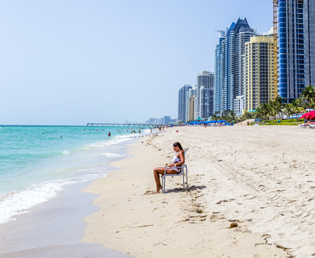 SUNNY ISLES BEACH, USA - AUG 2014: woman enjoys the Jade beach. Jade Beach and Ocean were completed in 2009 with a elevation of 549 feet located at 170th Street and Collins Avenue at Sunny Isles Beach, USA.のeditorial素材