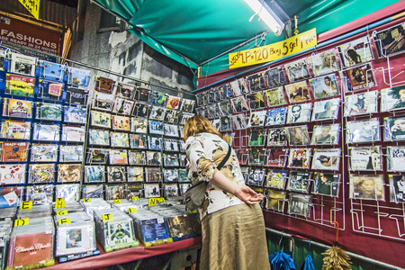 BANGKOK, THAILAND - JAN 9, 2008: woman looks for music CDs at the street market in Bangkok, Thailand. Bankok is famous for its CD copy piracy and prices are extremely low.のeditorial素材