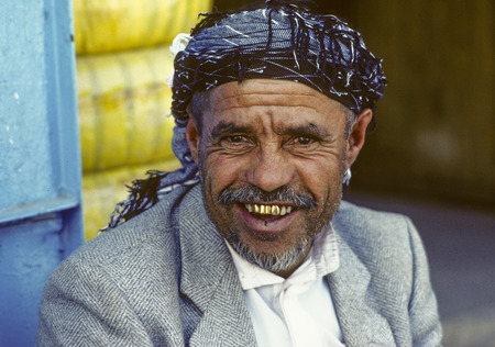 SANAA, YEMEN - JUNE 30, 1991: portrait of old smiling man in Sanaa, Yemen. The man wears gold teeth which are a symbol for wealth and rich people,のeditorial素材