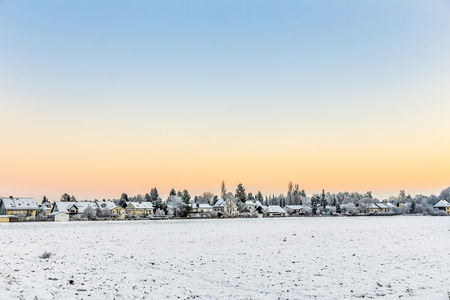 snow covered fields with settlement at the horizon in Munich,Germanyの写真素材