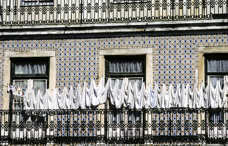 clothes line in front of an old lisbon house with typical tilesの写真素材