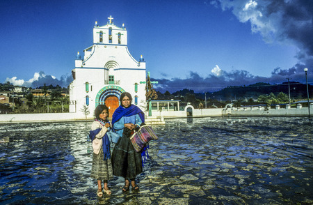 CHAMULA, MEXICO - June 10, 1993: mother with child sells handmade souvenirs in rain at the church in  San Juan Chamula, Mexico.のeditorial素材