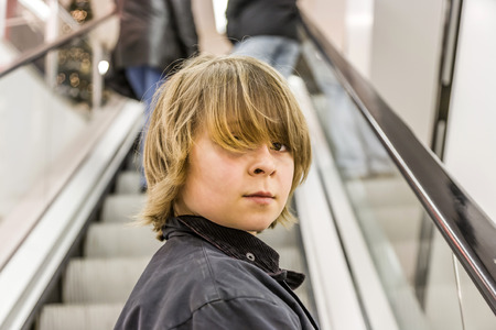 portrait of child on moving staircase in the shopping centerの写真素材