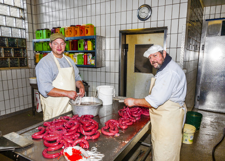 HOESBACH, GERMANY - OCT 15, 2009: butcher prepares fresh sausage in Hoesbach, Germany. The average person in Germany will consume up to 61 kg  of meat in a year.のeditorial素材