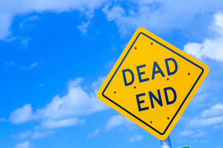 dead end street sign under blue sky with cloudsの写真素材