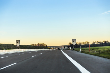 BURGAU, GERMANY - DEC 23, 2014: German highway  A8 with cars in sunset near Burgau, Germany. Bundesautobahn 8 (Federal Motorway 8)  is an autobahn in southern Germany that runs 497 km.のeditorial素材