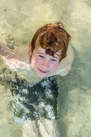 cute young boy has fun in the oceanの写真素材