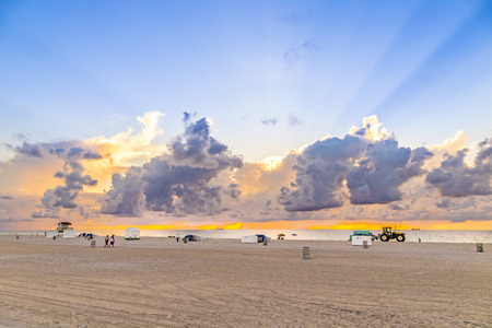 MIAMI, USA - AUG 7, 2013: people in late afternoon walk along south beach and enjoy the sunset in Miami, USA. South beach is famous for spectacular sunsets.のeditorial素材