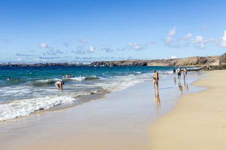 PLAYA BLANCA, SPAIN - NOV 18, 2014: Many tourists enjoy Papagayo beach on a sunny  day in Playa Blanca, Spain. The beaches belong to a protected nature area.のeditorial素材