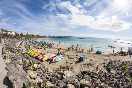 PLAYA BLANCA, SPAIN - JAN 1: people enjoy lying at the Beach Playa Dorada on January 01,2011 in Playa Blanca, Spain. The artifical beach was renovated in 2010 with additional white sand.のeditorial素材