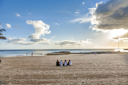 ARRECIFE, SPAIN - JAN 1, 2010: young people wearing Bro tanks sit at the beach and discuss in Arrecife, Spain. Youth culture is also defined by different clothing like Bro tanks.のeditorial素材