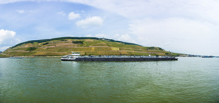 cargo ship on river Rhine in Bingen, Germany. The rhine valley in Bingen is a very important shipping route to Amsterdam.の写真素材