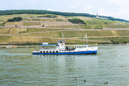 BINGEN, GERMANY - MAY 24, 2015: passenger ferry cruises with passengers at river Rhine in Bingen, Germany. The lovely rhine valley is a world heritage site.のeditorial素材