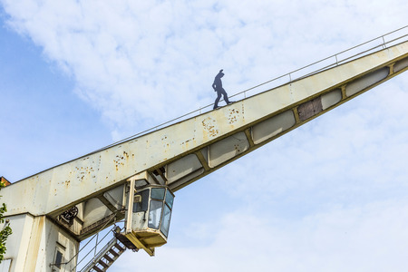 BINGEN, GERMANY - MAY 24, 2015: old crane with iron man in Bingen, Mainz. Artist Hubertus von der Goeltz created that man  walking at crane in 2007.のeditorial素材