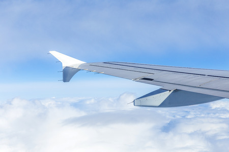 Wing of an airplane flying above the clouds