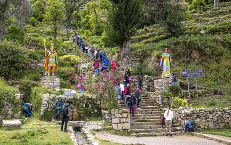 YUMANI, BOLIVIA - JAN 20, 2015: tourists climb up the old incan steps to the temple in Yumani, Bolivia. People live at this islas del sol in the Titicaca lake and earn money by tourism.のeditorial素材