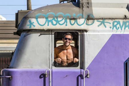 MARSEILLE, FRANCE - JULY 9, 2015: attractive train conductor in his train is proud to show his...