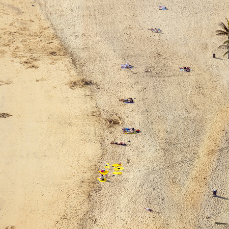 ARRECIFE, SPAIN - JAN 1, 2011: beach with tourists in summer in Arrecife, Spain. Beach El Reducto is granted a blue flag by the European Union. This seal for cleanness must renewed yearly.のeditorial素材
