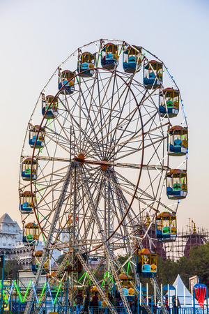 DELHI, INDIA - NOV 11, 2011: people enjoy the big wheel in the amusement park in Delhi, India in front of the red fort. The prices are very low to enable poorer people a ride.のeditorial素材
