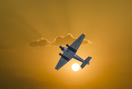 SCHWALBACH, GERMANY - MAY 31, 2015: Junkers Ju52 D-AQUI  flights over the Taunus region at cloudy sky in Schwalbach, Germany. The flight is bookable by Lufthansa as classic flight.のeditorial素材