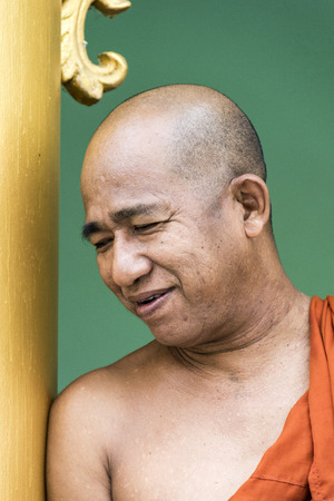RANGOON, MYANMAR - AUG 12, 2015: portrait of smiling monk in Shwedagon Pagoda in Rangoon.  Every male burmese wents at least one year as monk to  a monastery.のeditorial素材