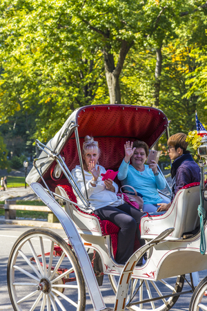 NEW YORK, USA - OCT 21, 2015: People enjoy carriage ride in Central Park  in Manhattan. Horse-Drawn Carriages are a wonderful way to experience the beauty of the Parのeditorial素材
