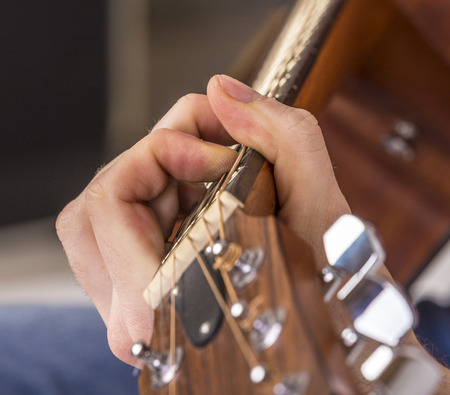 detail of fingers, string and hand of guitar playerの写真素材