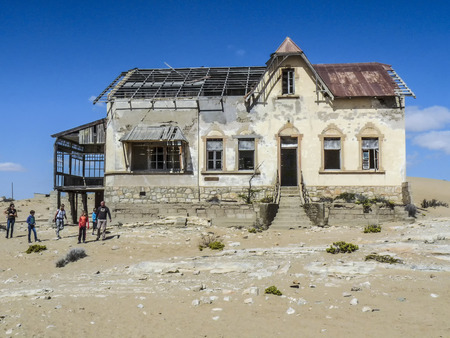 KOLMANSKOP, NAMIBIA - AUG 13, 2014: people visit Ghost town Kolmanskop in the Namibia desert. The former german town was left with end of german colonialism end of world war 2.のeditorial素材