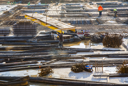 HOFHEIM, GERMANY - OCT 19, 2009: workers assist the crane carrying building material to the construction site. Safety regulations at construction sites are very strict in Germany and controlled by officials.のeditorial素材