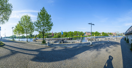 BREMEN, GERMANY - MAY 12, 2016: River Weser in city center. Sightseeing boats anchored at river bank. Text on flags: 'Town at River - Schlachte'. (Schlachte is the name of the quarter).のeditorial素材